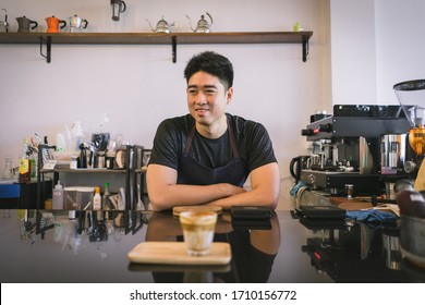 Cheerful success Asian barista! - The coffee shop startup owner stitting at the coffee counter