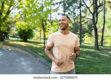 Cheerful and successful hispanic man jogging in the park, man running on a sunny day, smiling and happy having an outdoor activity. - Powered by Shutterstock