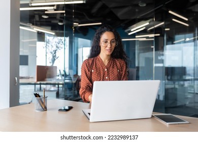 Cheerful   successful indian woman programmer at work inside modern office  tech support worker and laptop typing keyboard smiling 
