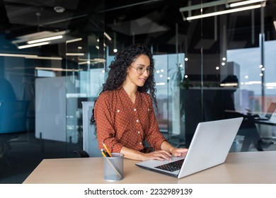 Cheerful and successful indian woman programmer at work inside modern office, tech support worker with laptop typing on keyboard smiling. - Powered by Shutterstock