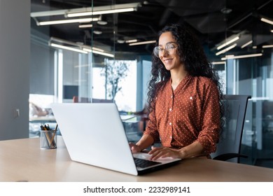 Cheerful and successful indian woman programmer at work inside modern office, tech support worker with laptop typing on keyboard smiling. - Powered by Shutterstock