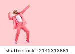 Cheerful successful man dancing funny making movements winner isolated on pink background. Funny man in pink formal suit celebrates his success having fun at copy space. Full length. Banner.