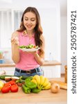 Cheerful svelte young woman eating vegetable salad