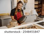 A cheerful and talented baker proudly presents a beautifully crafted cake in a stylish and inviting bakery