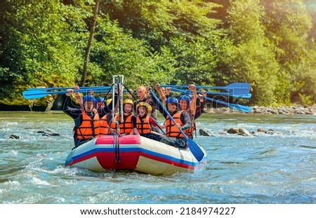 cheerful team is rafting on a mountain river