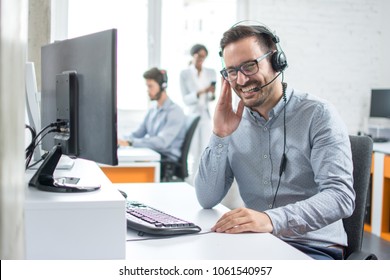 Cheerful technical support dispatcher talking with customer using headset in call center - Shutterstock ID 1061540957