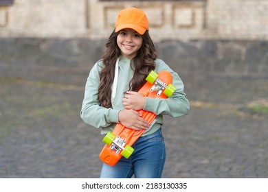 cheerful teen child skater with skateboard. girl with penny board. hipster girl with longboard skate