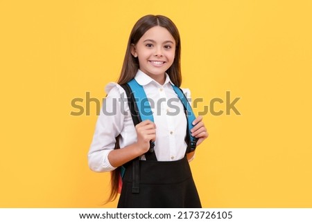 cheerful teen girl in school uniform carry backpack, school fashion