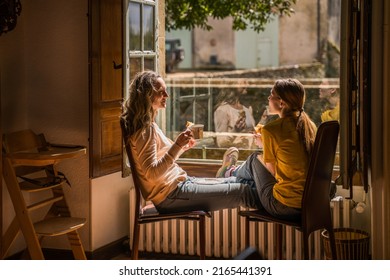 Cheerful teen girl spending time with her parent while drinking tea - Shutterstock ID 2165441391