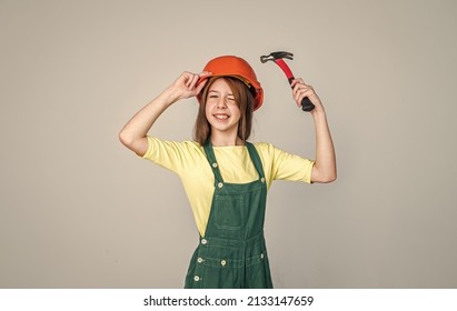 Cheerful Teen Girl In Working Uniform And Helmet Use Hammer, Repair