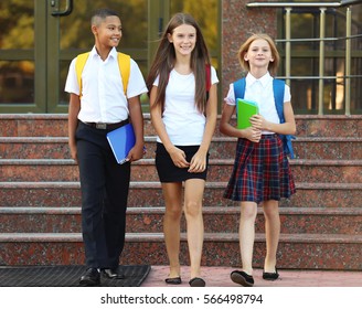 Cheerful Teenagers With Backpacks And Notebooks Leaving School