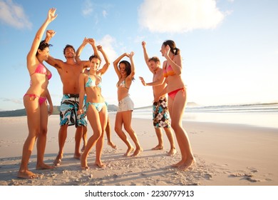 Cheerful teenagers dancing on the beach. Portrait of happy teenagers dancing on the beach. - Powered by Shutterstock