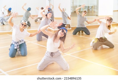 Cheerful Teenagers Hip Hop Dancers Kneeling On Floor During Group Dance Workout