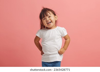 Cheerful three year old Asian girl smiles standing on pink isolated background. Beautiful Korean female child expresses a joyful mood on an isolated. - Shutterstock ID 2365428771