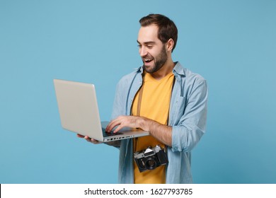 Cheerful traveler tourist man in casual clothes with photo camera isolated on blue background. Passenger traveling on weekends. Air flight journey concept. Working on laptop pc computer booking hotel - Shutterstock ID 1627793785
