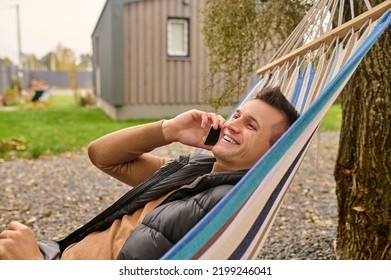 Cheerful Vacationer Talking On His Smartphone Outside