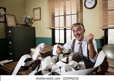 Cheerful Vintage Accountant Surrounded By Adding Machine Paper Tape In His Office.