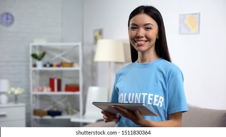 Cheerful Volunteer With Tablet Smiling Camera, Online Fundraising Application