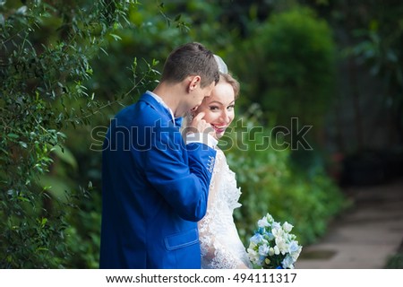 Cheerful wedding couple on walk in the park. Bride and groom