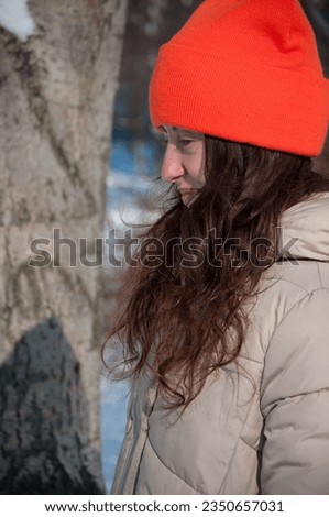 cheerful winter woman in orange warm hat in snow wintertime. winter fashion of woman in warm hat with wintertime snow.