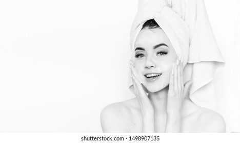 Cheerful Woman Applying Foam For Washing On Her Face. Model With Towel On Head With Healthy Glow Perfect Smooth Skin. Young Girl Enjoys Facial Skincare Routine. Black And White.