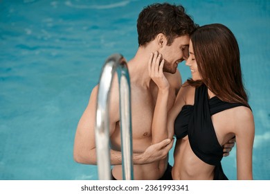 cheerful woman in black swimsuit touching face of happy boyfriend in swimming pool, vacation romance - Powered by Shutterstock