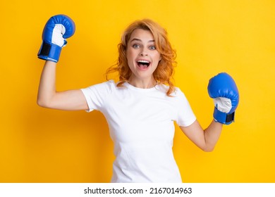 Cheerful woman celebrating victory. Winner female boxer Isolated on yellow background. Excited win woman in boxing gloves. Winning success power woman concept. Girl fight for success.