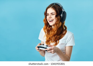 Cheerful Woman Gamer In Headphones With A Gamepad In The Hands Of The Gaming Console Blue Background