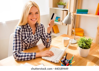 Cheerful woman holding credit card and doing banking
