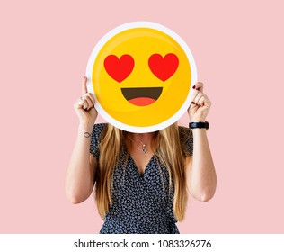Cheerful woman holding emoticon icon