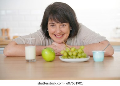 Cheerful Woman In Kitchen Eating Healthy Food                 