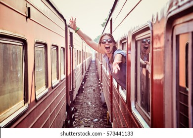 cheerful woman looking out the window of the old train