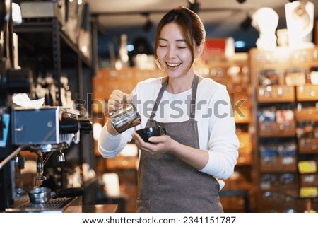 Cheerful woman making a coffee cup in cafe,Barista holding a cup of hot coffee for the first Morning.
