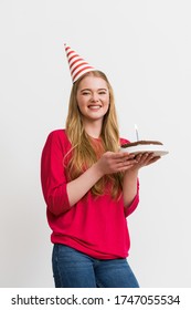 Cheerful Woman In Party Cap Holding Birthday Cake Isolated On White