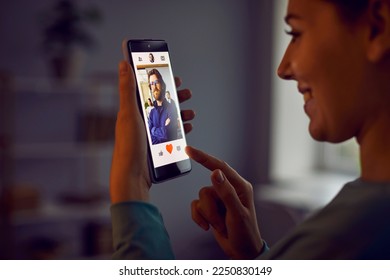 Cheerful woman presses red heart button on profile of man she likes in dating app. Smartphone with modern app in hands of woman. Concept of finding love, communication and flirting online. Close up. - Powered by Shutterstock