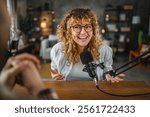 cheerful woman radio host with headphones laugh while record podcast with man colleague in home studio