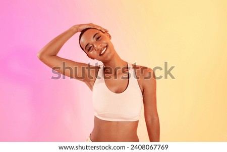 A cheerful woman with a shaved head poses with her hand on her head, sporting a wide smile and a white sports bra, against a gradient pink and yellow backdrop. Fit, sport and health care