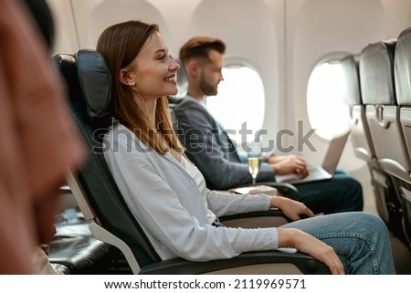 Cheerful woman sitting in passenger chair in airplane Foto stock © 