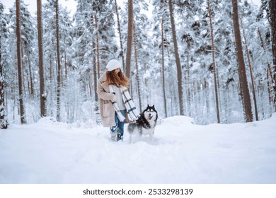 Cheerful woman in the snow playing with a husky dog. Friendship. Domestic dog concept. - Powered by Shutterstock