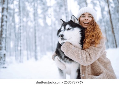 Cheerful woman in the snow playing with a husky dog. Friendship. Domestic dog concept. - Powered by Shutterstock