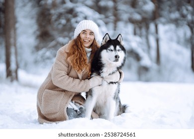 Cheerful woman in the snow playing with a husky dog. Friendship. Domestic dog concept. - Powered by Shutterstock