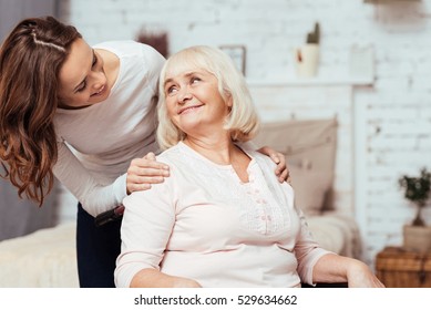 Cheerful woman taking care of her grandmother in wheelchair - Powered by Shutterstock