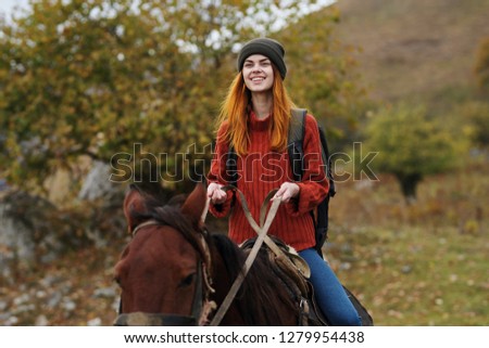 Cheerful woman Tourist rides a horse on nature                  