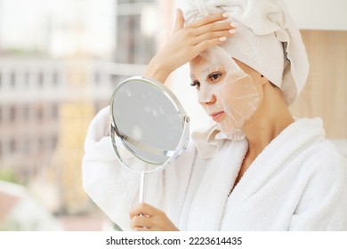 Cheerful woman with a towel on her head face mask clean skin - Shutterstock ID 2223614435