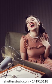 Cheerful Woman Using A Fan To Cool Off