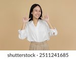 A cheerful woman in a white blouse making the 