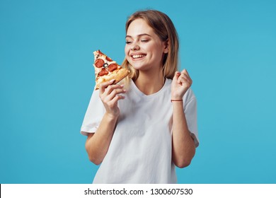 Cheerful woman White T-shirts with pizza in hands on a blue isolated background