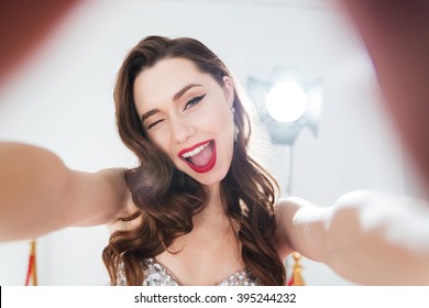 Cheerful woman winking and making selfie photo 