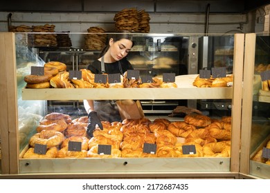 cheerful woman working at her bakery smiling standing near the showcase with delicious desserts, entrepreneur profession positivity small business owner, copy space - Powered by Shutterstock