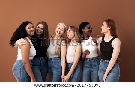 Cheerful women of different body types and ages standing together in studio